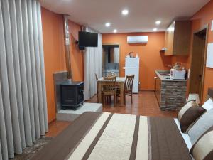 ein Wohnzimmer mit einem Sofa und einem Tisch sowie eine Küche in der Unterkunft Estúdio de Amor in Castelo de Paiva
