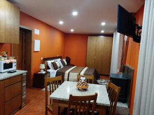 - une chambre avec un lit et une table avec des chaises dans l'établissement Estúdio de Amor, à Castelo de Paiva