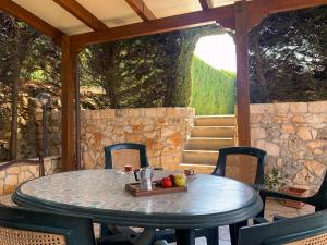 a table and chairs on a patio with a stone wall at Villa parco la Ruta, Piscina e relax in Noci