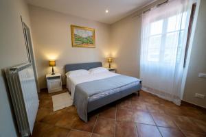サン・ジョヴァンニ・ヴァルダルノにあるAgriturismo Valleverdeのベッドルーム1室(ベッド1台、ランプ2つ、窓付)
