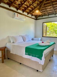 um quarto com uma cama grande e um cobertor verde. em Mirante Caraiva em Caraíva