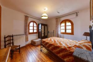 una camera da letto con un letto, un tavolo e finestre di Casa Rural El Molino a Tobed