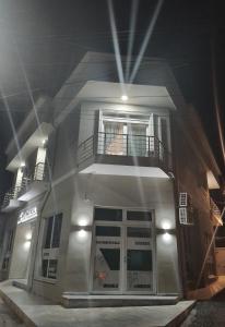 a white building with a balcony on top of it at Ajilin Hotel Rooms in Korçë