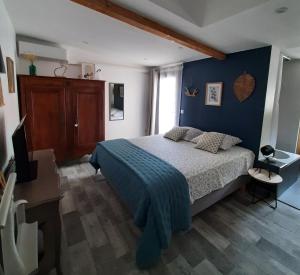 a bedroom with a bed and a blue wall at La Colinière, Chambre d'hôtes in Aix-en-Provence