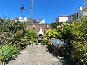 a garden with a table and some plants at Fig Tree House, family friendly, 1 min Sea in Kent