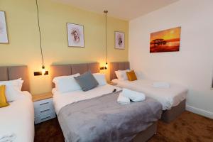 a bedroom with two beds and two lamps at Richmond House in Leeds