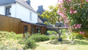 a garden in front of a house with pink flowers at Confortable maison de vacances 3 étoiles, 6p in Ploeren