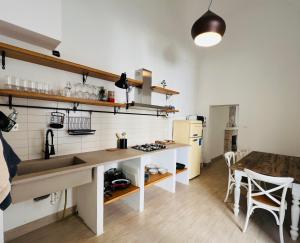 cocina con fregadero y mesa en una habitación en 4Cats - Alloggio incantevole in centro, en Lecce