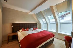 una camera da letto con un letto con una coperta rossa di Après Post Hotel a Stuben am Arlberg