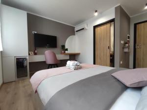 sypialnia z dużym białym łóżkiem i biurkiem w obiekcie Boutique rooms by Petrič winery w mieście Dobravlje