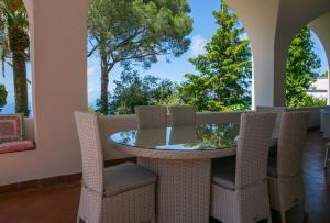 - une table et des chaises sur une terrasse couverte avec des arbres dans l'établissement Villa, à Anacapri