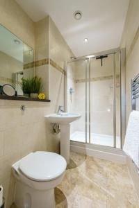 a bathroom with a toilet and a sink and a shower at K Suites - Barton Court in Warrington