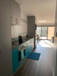 una cocina con armarios azules y un horno de fogón azul en North Hobart, Tranquil Retreat, No Stairs, Access en New Town