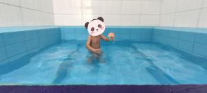 una persona disfrazada de oso panda en una piscina en Квартира в Радуга WEST en Koshkolʼ