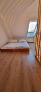 uma cama num quarto com piso em madeira em Chatki Niwkii u Zbója Studio z antresolą em Krościenko