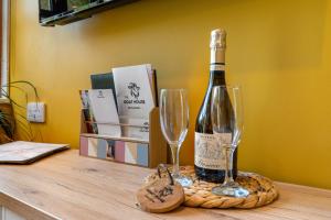una bottiglia di vino e due bicchieri su un tavolo di Romantic, secluded cottage in Cardinham Woods, Cornwall a Cardinham