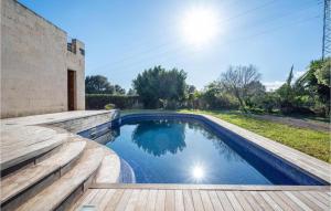 una piscina en un patio trasero con terraza de madera en Villa de lujo con piscina, jacuzzi, jardín y terraza, en Marratxí 