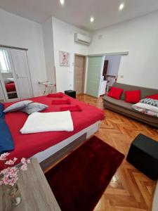 a bedroom with a large red bed and a couch at Apartmani Tower in Rijeka