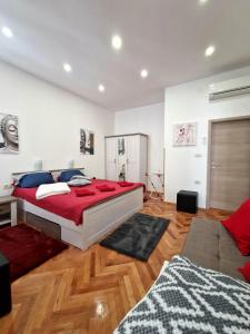 a bedroom with a large red bed and a couch at Apartmani Tower in Rijeka