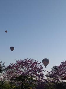 three hot air balloons are flying in the sky at Aldeia Canastra Pousada in São Roque de Minas