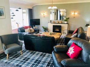 a living room with leather furniture and a fireplace at Distant Hills Guest House in Spean Bridge