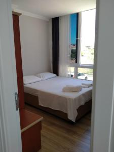 a bedroom with a bed and a large window at VENÜS PARK APART SUİTES in Cesme