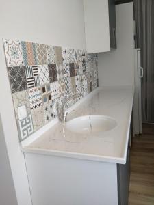 fregadero blanco en una cocina con azulejos en la pared en VENÜS PARK APART SUİTES en Cesme