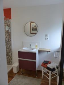 een badkamer met een wastafel, een spiegel en een kruk bij Cottage des Mézières in Saint-Germain-sur-Ay