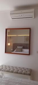 a mirror on a wall with a bed in a room at Hotel Nou Can Guillem in Cala Figuera