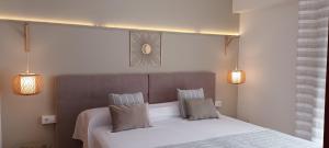 a bedroom with a white bed with two pillows at Hotel Nou Can Guillem in Cala Figuera