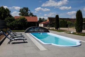 a swimming pool with two lounge chairs and a swimming poolvisor at Agroturystyka Pod Dębem in Łagów