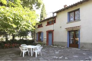 a table and chairs in front of a house at Les Planettes in Saint-Sernin-lès-Lavaur