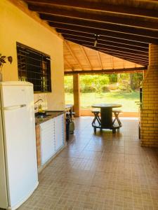 a kitchen with a white refrigerator and a table at Chácara em Brotas in Brotas