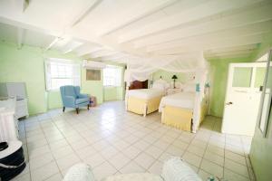 a large room with two beds and a blue chair at The Great House in Saint Peter