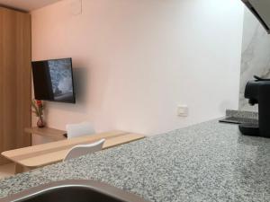 a kitchen with a counter and a tv on a wall at Joan Miró Luxury Torremolinos in Torremolinos