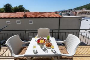 a table with food and drinks on a balcony at Villa Ševo Baška Voda in Baška Voda