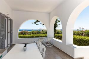 a room with two arched windows and a view of the ocean at Golden Beach Hotel in Chrissi Akti