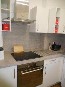 a kitchen with white cabinets and a stove top oven at Spacieux F5 au parc arboré in Orsay
