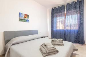a bedroom with a bed with towels on it at Profumo di Vacanza in Assemini