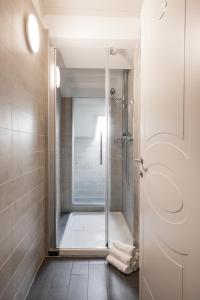 ロカルノにあるホテル アレクサンドラのバスルーム(ガラスドア付きのシャワー付)