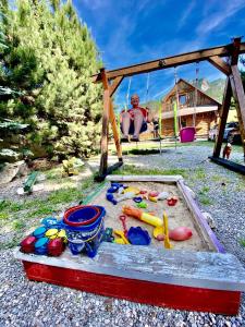 een jongen in een schommel met speelgoed in een zandbak bij Mobilný domček in Terchová +2 foto's
