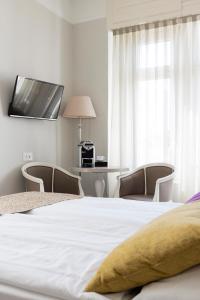 Schlafzimmer mit einem Bett mit 2 Stühlen und einem Tisch in der Unterkunft Hotel Alexandra in Locarno