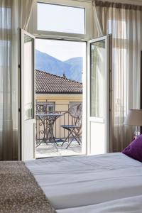 a bedroom with a bed and a view of a patio at Hotel Alexandra in Locarno