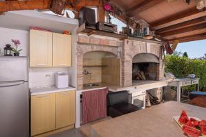 Il comprend une cuisine équipée d'un four en pierre et d'une table. dans l'établissement HH Korsa with shared pool, à Sveti Lovreč Pazenatički