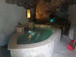 a large bath tub in a stone room with at Il Daviduccio ibla in Ragusa