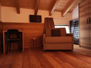 a living room with a chair and a flat screen tv at Agritur Fioris in Nanno