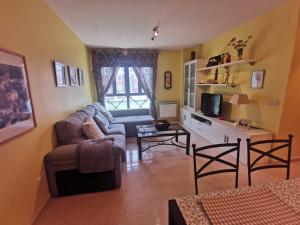 un soggiorno con un divano e un tavolo di Apartamento de 3 dormitorios con piscina - Riaza Vacacional a Riaza
