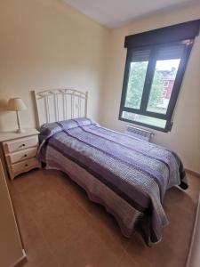 una camera da letto con un letto e una finestra di Apartamento de 3 dormitorios con piscina - Riaza Vacacional a Riaza