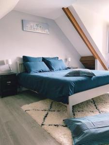 Un dormitorio con una cama con sábanas azules. en Très joli appartement équipé au calme en Rozay-en-Brie