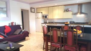 een keuken en een woonkamer met een tafel en een bank bij Maria Planta in Calella de Palafrugell
